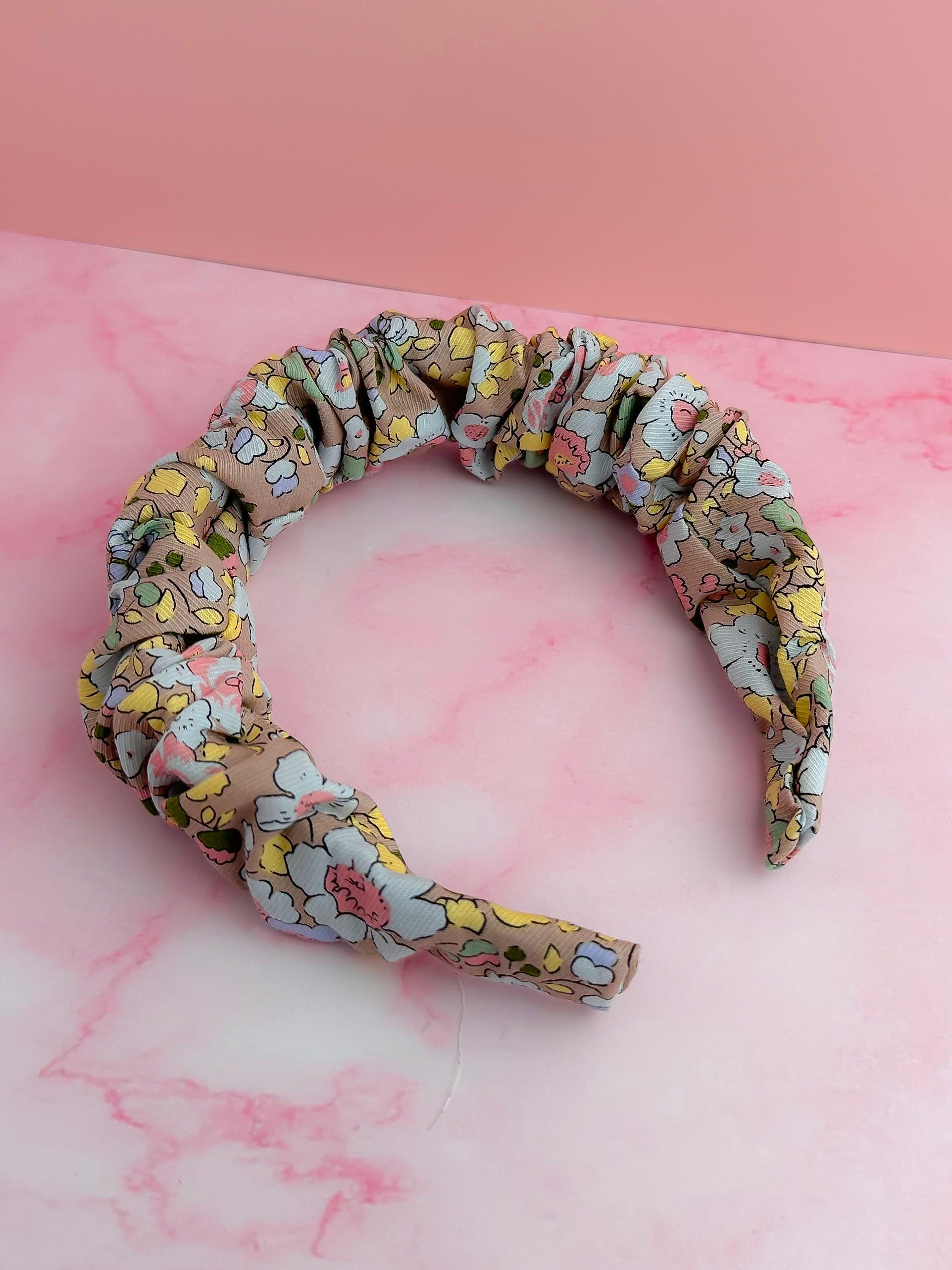 Floral patterned headband on a pink marble background